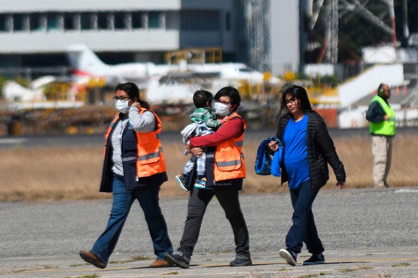 Agentes de migración de Guatemala con mascarillas protectoras recibieron en el Aeropuerto...