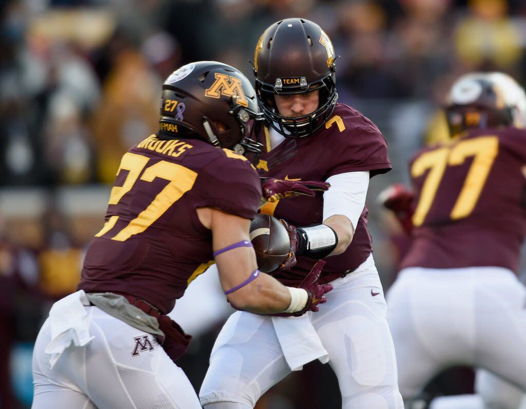 MINNEAPOLIS, MN - NOVEMBER 28: Mitch Leidner #7 of the Minnesota Golden Gophers hands the...