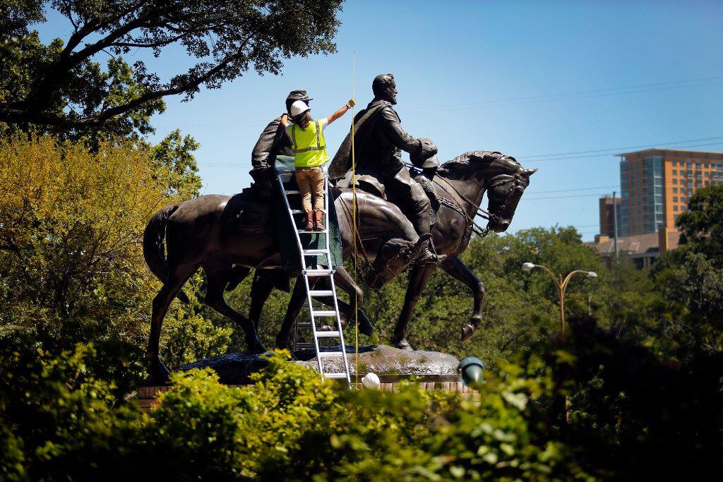 A crewman from Howell Crane and Rigging Inc measured the height of the Robert E. Lee statue...