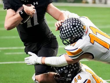 Denton Guyer quarterback Jackson Arnold is brought down by Highland Park linebackers William...