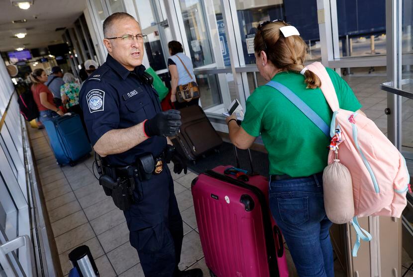 U.S. Customs and Border Protection officer Raul Flores guides travelers into a pedestrian...