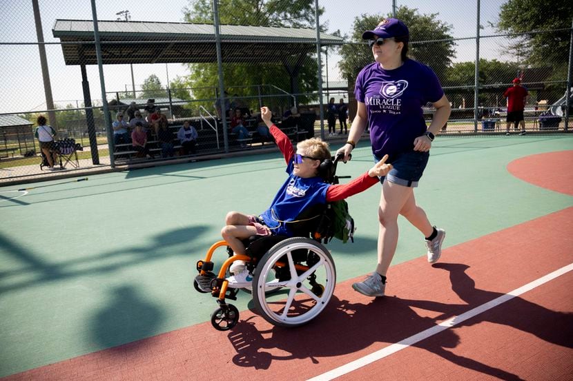 Will Woleben, 11, and buddy Allison McCarthy run the bases during a Miracle League baseball...