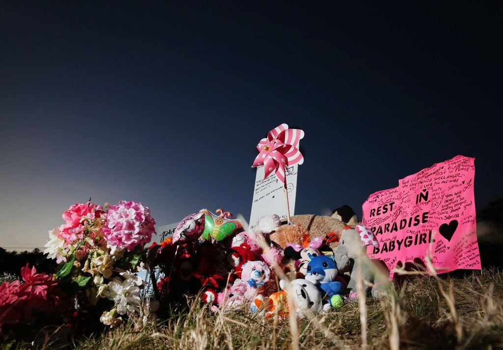 A makeshift memorial of flowers, stuffed toys and written messages stands near where the...
