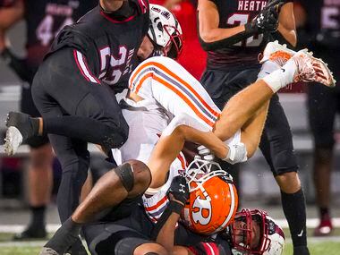 Rockwall wide receiver Caden Marshall (11) is upended by Rockwall-Heath linebacker  Alan...