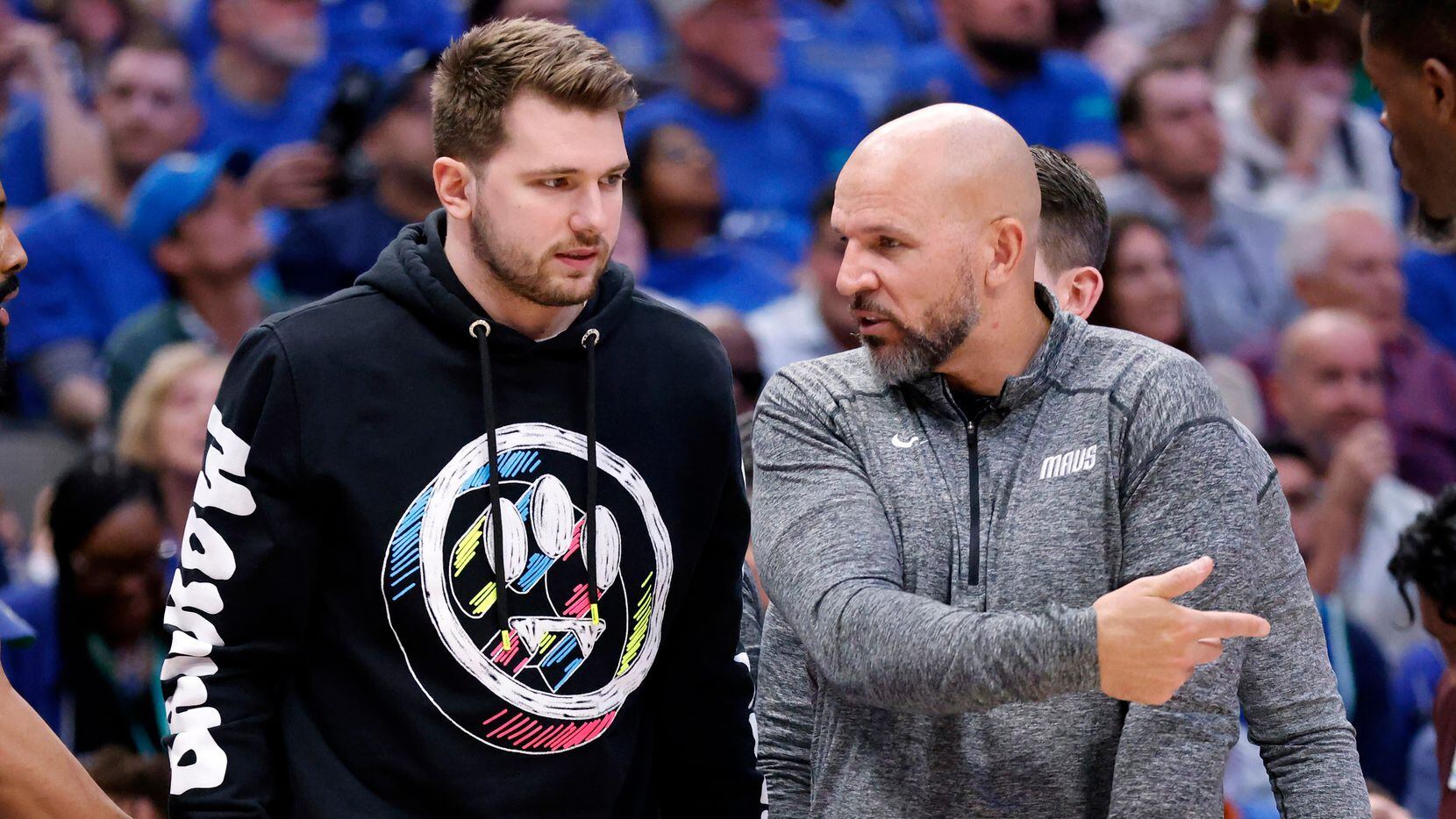 Dallas Mavericks guard Luka Doncic (left) listens to an explanation from head coach Jason...