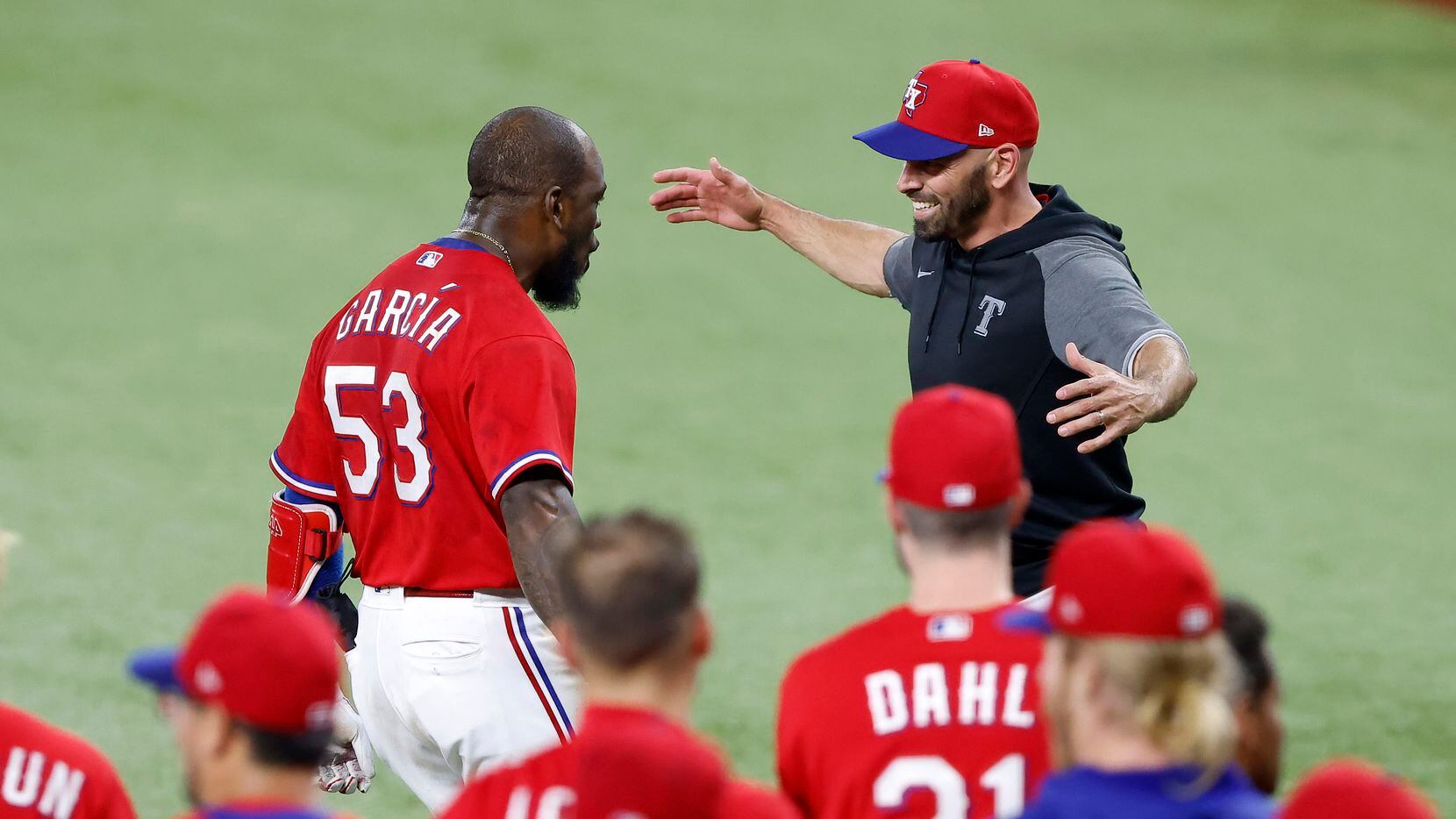 Texas Rangers batter Adolis Garcia (53) received a big hug from manager Chris Woodward after...
