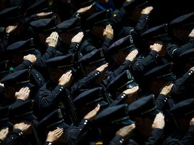 Law enforcement officers salute as the casket carrying Dallas police Sr. Cpl. Lorne Ahrens...