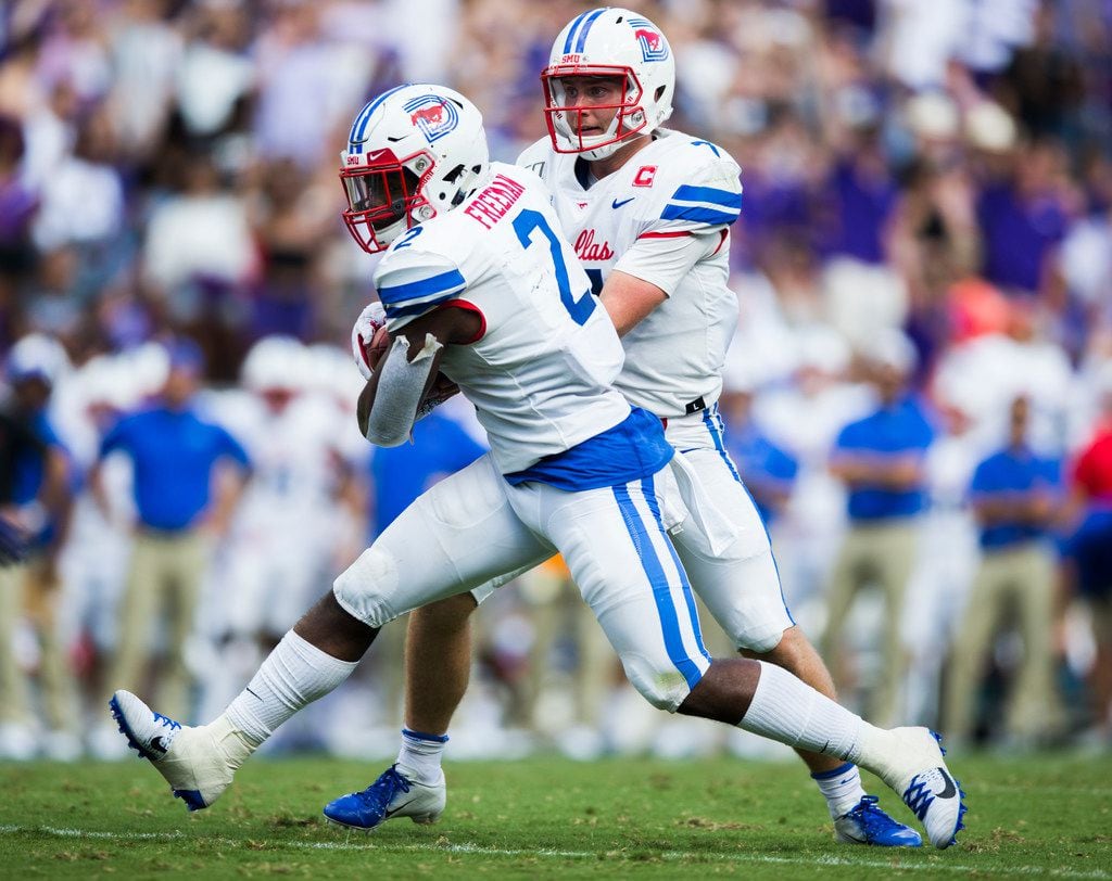 Southern Methodist Mustangs quarterback Shane Buechele (7) hands off the ball to Southern...