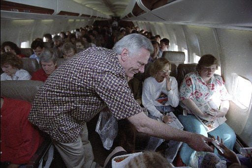 Southwest Airlines' Herb Kelleher passes out peanuts to customers on a flight from Dallas to...