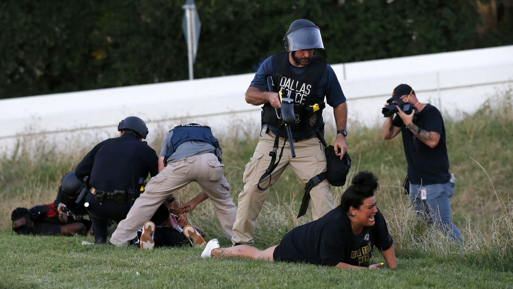 Dallas Police Sgt. Roger Rudloff stands over Jantzen Verastique (center) May 30, 2020, after shooting her with pepper balls as photojournalist Christopher Rusanowsky (right) photographs officers arresting protestors downtown.