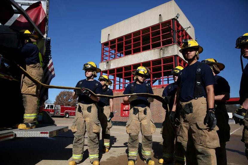 Los aprendices de bomberos preparan una manguera durante un entrenamiento en Dallas. ROSE...
