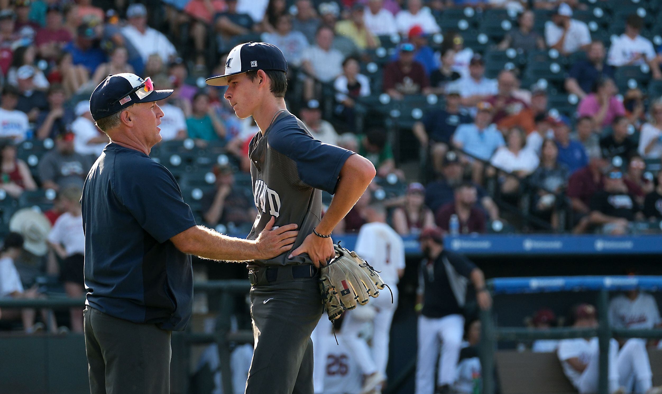 Flower Mound coach, Danny Wallace talks with pitcher, Zack James, (7), after getting out of...