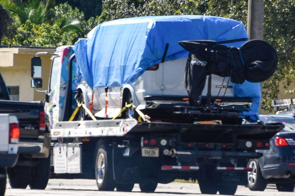 A van covered in blue tarp is towed by FBI investigators in Plantation, Fla., in connection...