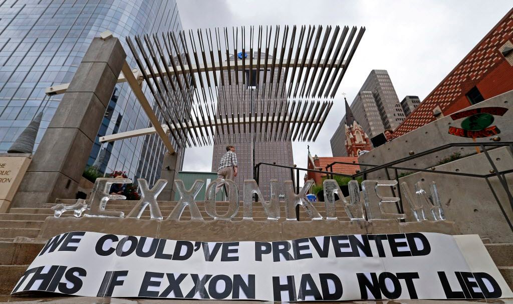  Activist Penelope Bisbee walked by an ice sculpture and sign at a protest across Morton H. Meyerson Symphony Center where the Exxon Mobil annual shareholder meeting was held Wednesday in Dallas. (Jae S. Lee/Staff Photographer)