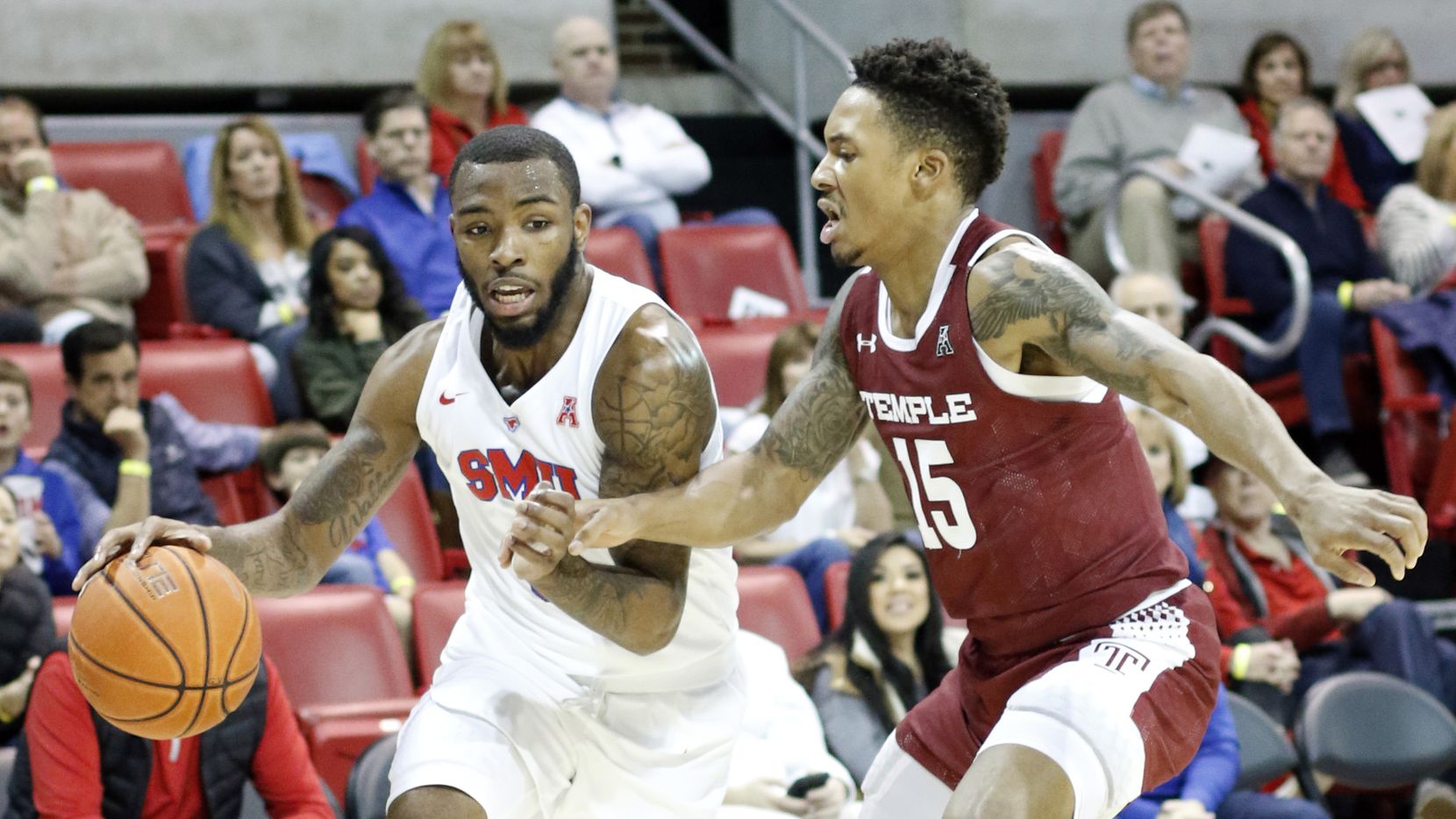 SMU guard Tyson Jolly (0) drives hard to the basket as he is defended by Temple guard Nate...