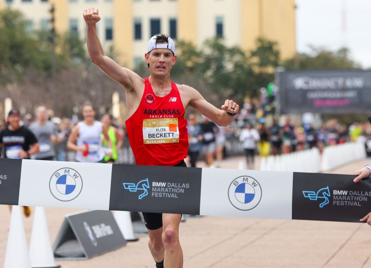 Cameron Beckett pumps his fists in the air as he crosses the finish line in first place at...