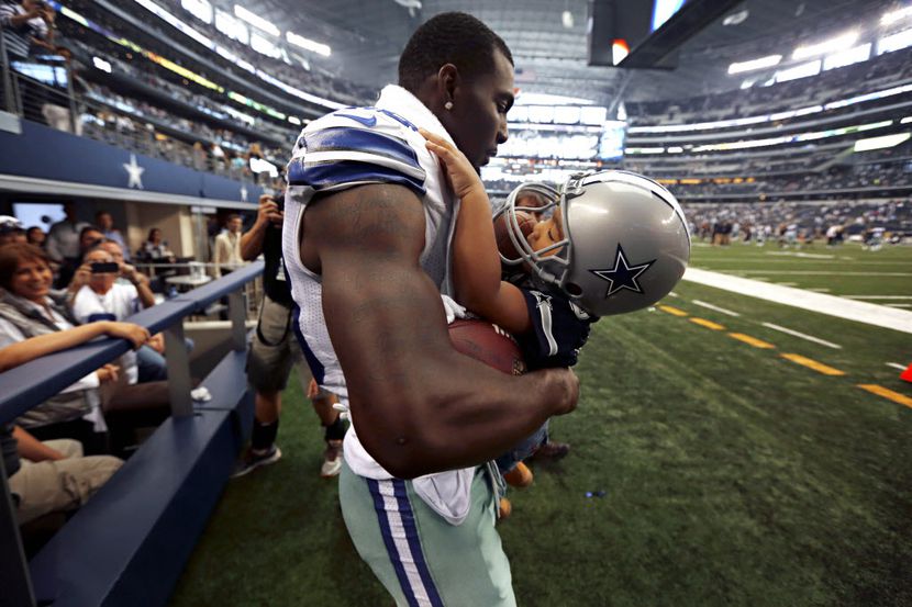 El jugador de los Dallas Cowboys Dez Bryant abrazo a su hijo Dez Jr en un partido en el 2013...