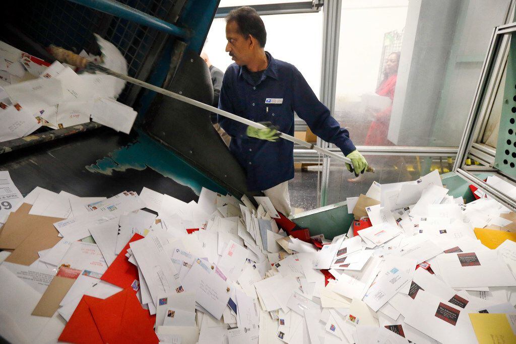 Mail handler Raju Chacko dumps a large bin full mail, mostly Christmas cards, to be canceled...