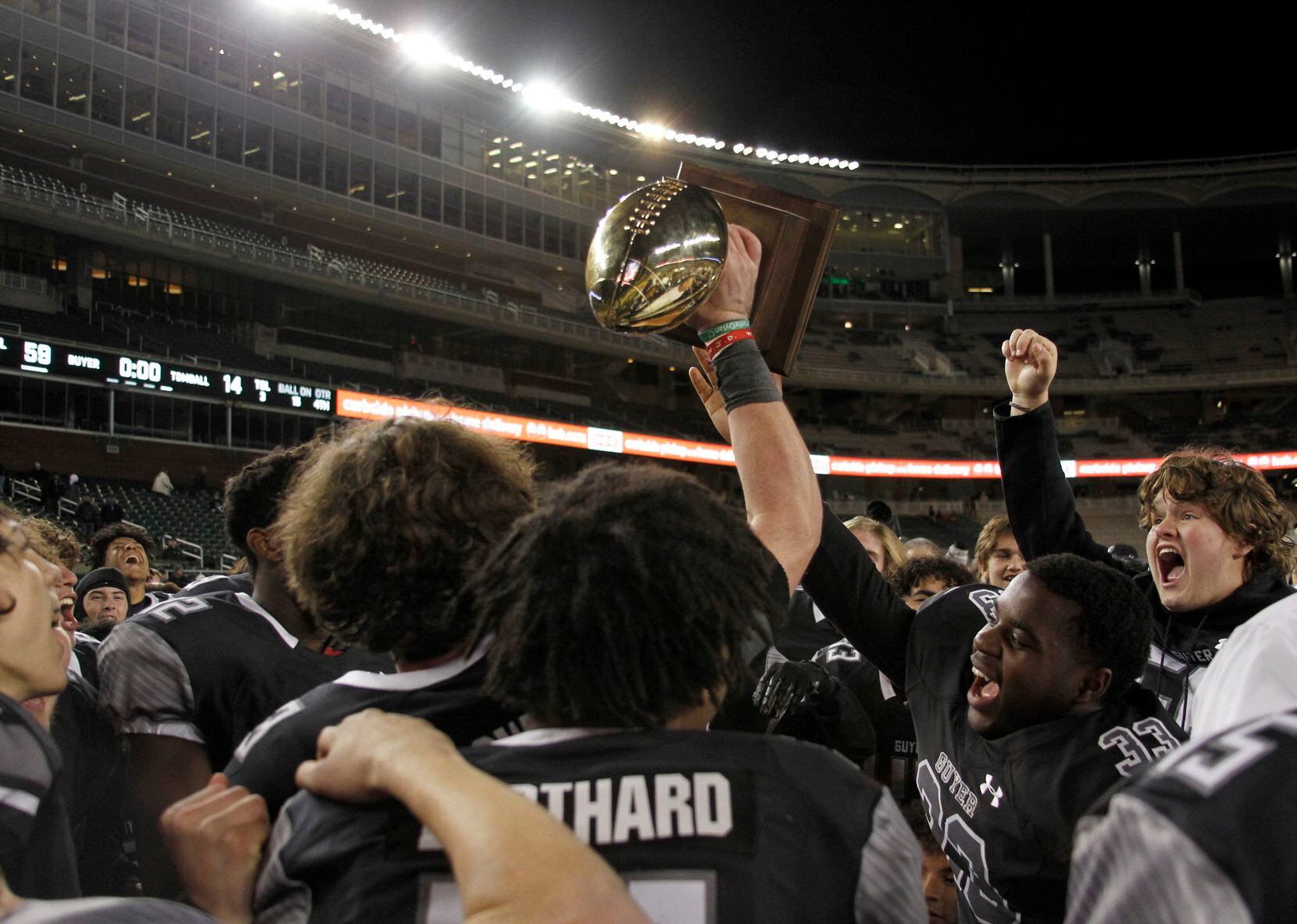 A jubilant group of Denton Guyer players are jubilant in their celebration of defeating...