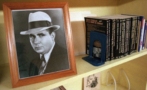 A picture of Robert  E. Howard sits on the shelf of the library along with some foreign...