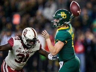 Baylor Bears quarterback Charlie Brewer (12) is threatened by Oklahoma Sooners defensive tackle Jalen Redmond (31) during the first quarter of an NCAA football game between Baylor University and Oklahoma University on Saturday, November 16, 2019 at McLane Stadium in Waco, Texas. (Ashley Landis/The Dallas Morning News)