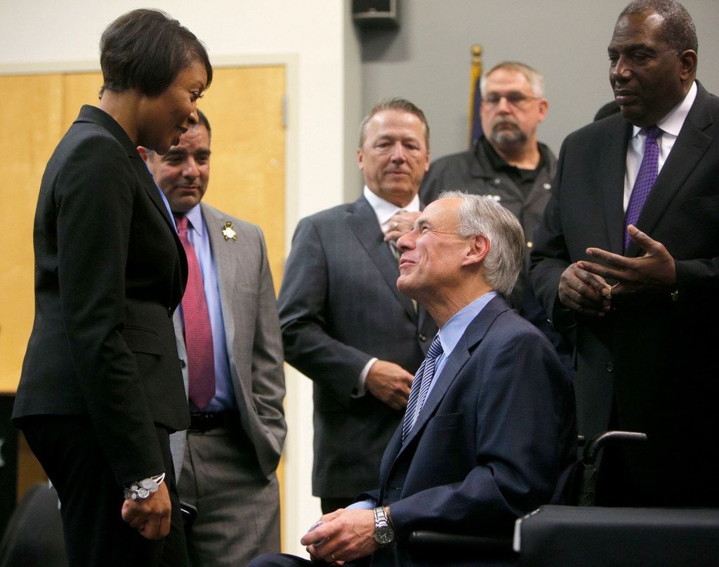 Gov. Greg Abbott speaks to Dallas Police Chief U. Renee Hall before a news conference...
