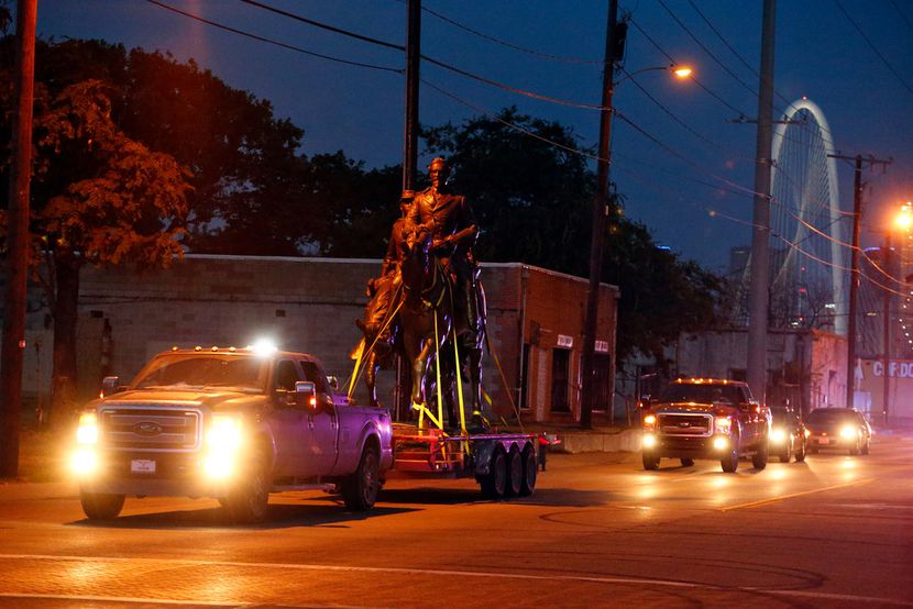 The Robert E. Lee statue received a police escort down Singleton Boulevard after its removal...