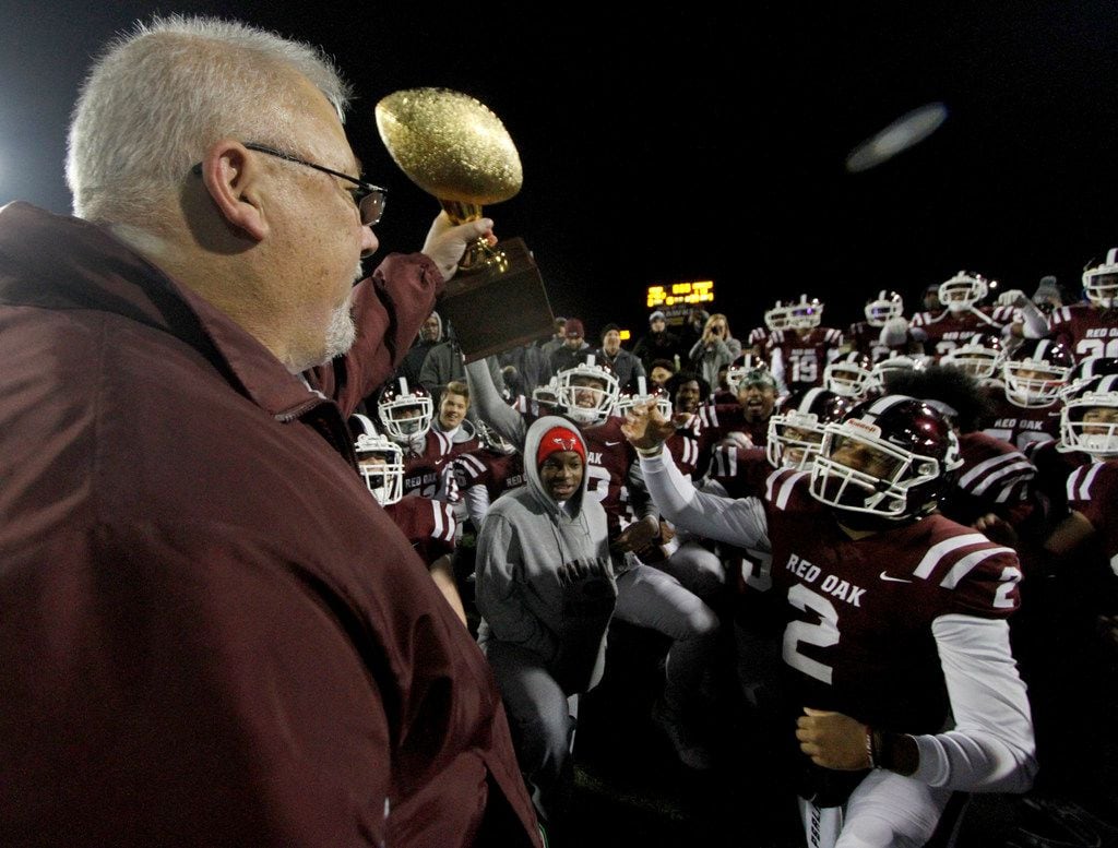 Red Oak ISD School Board President John Anderson presents the district trophy to members of...