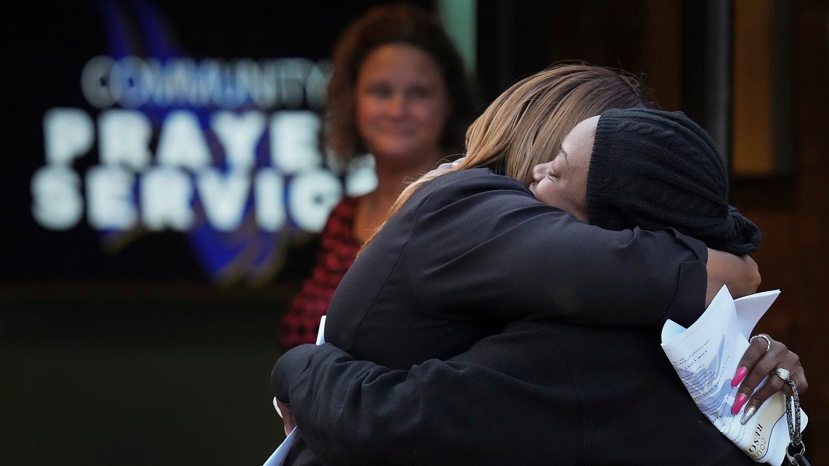 Shaniqua Williams (facing), a family member of the shooting victim, was consoled by Melinda...