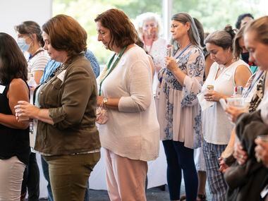 Eve Juarez (far left) computer science department chair at Ursuline Academy of Dallas, bows her head for prayer with other teachers after attending a workshop, on Aug. 13.