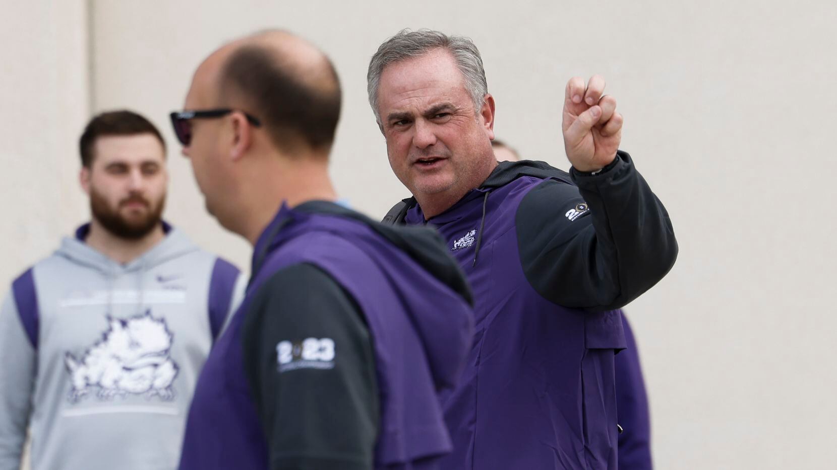 TCU coach Sonny Dykes does the Frogs' hand sign as he and other TCU football players,...