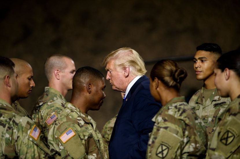 El presidente Donald Trump pasa junto a varios solados en Fort Drum, Nueva York, el 13 de...