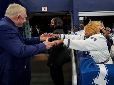 Dallas Cowboys owner and general manager Jerry Jones reaches out to fan Carolyn Price before an NFL Wild Card playoff football game at AT&T Stadium against the San Francisco 49ers on Sunday, Jan. 16, 2022, in Arlington.