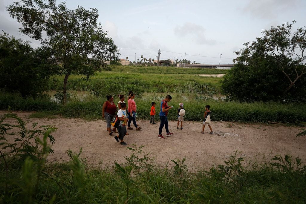 Migrants from Honduras, Nicaragua, and Mexico walk with two local friends along the Rio...
