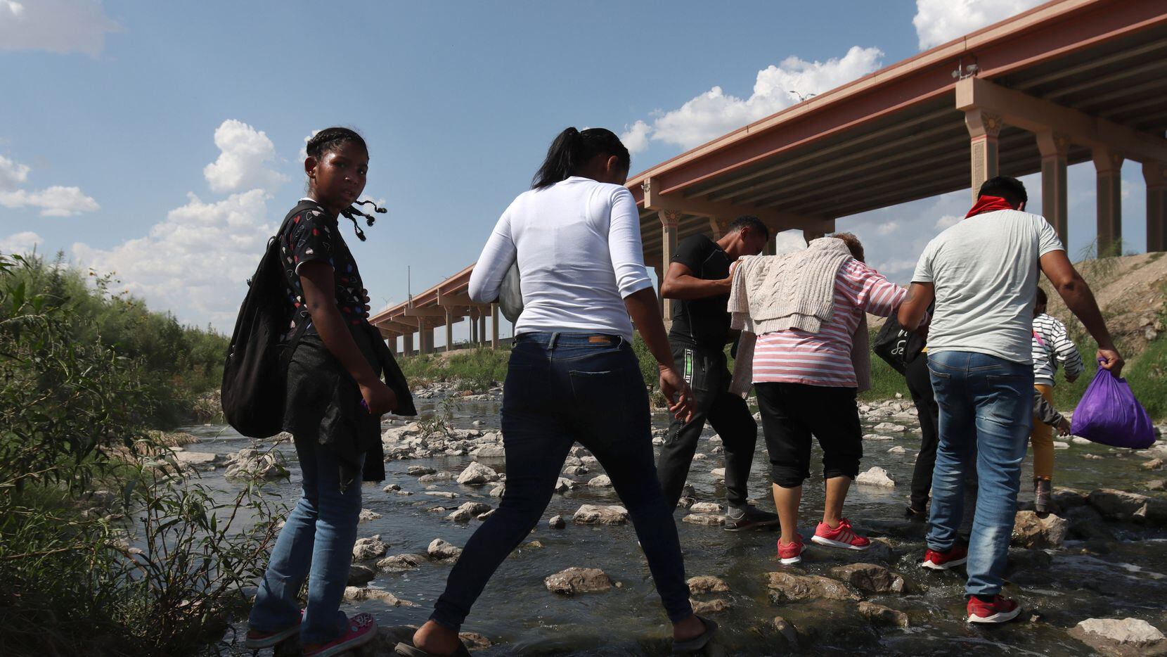 Un grupo de migrantes cruza sobre el riachuelo en el Rio Grande desde Ciudad Juárez a El...