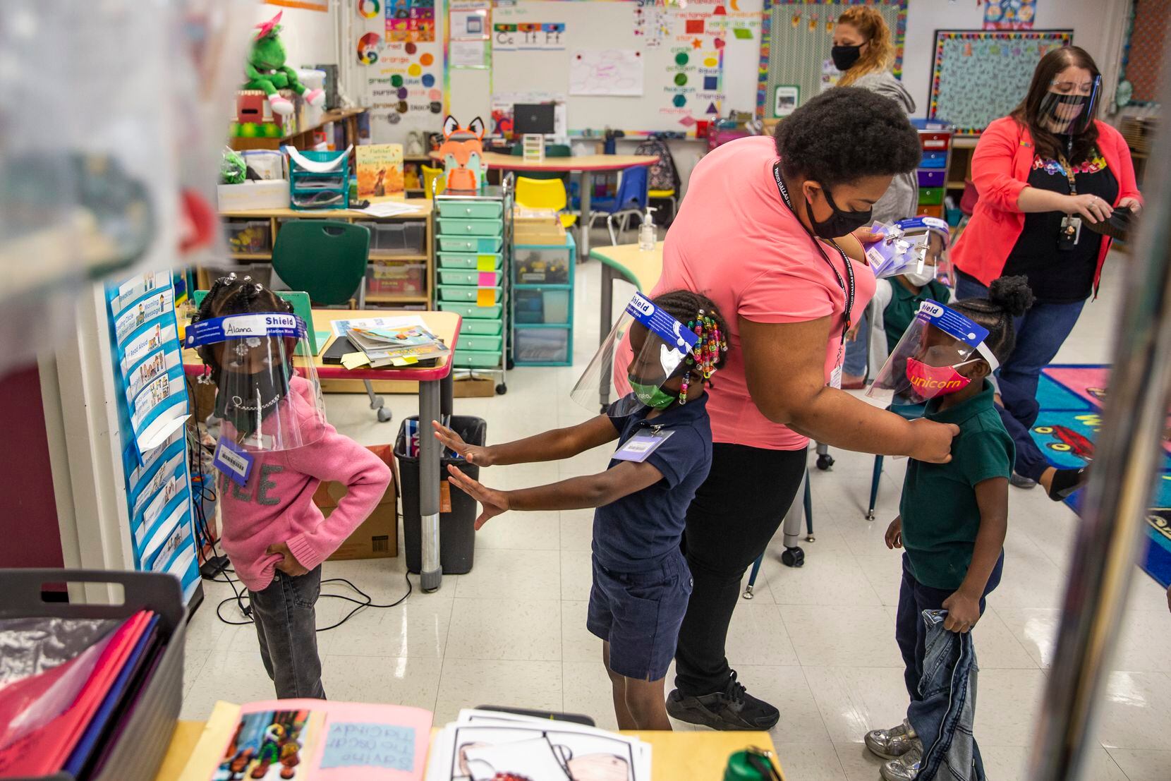 Teachers all over North Texas have coped with myriad safety challenges during the pandemic. In this October 2020 photo, teachers help pre-K students at N.W. Harllee Early Childhood Center in Dallas prepare for lunch.