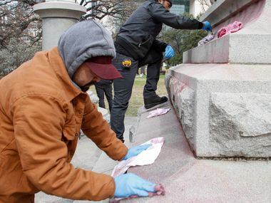Jorge Meza, left, and Humberto DeGarrio from Bronze Conservation clean graffiti from the...