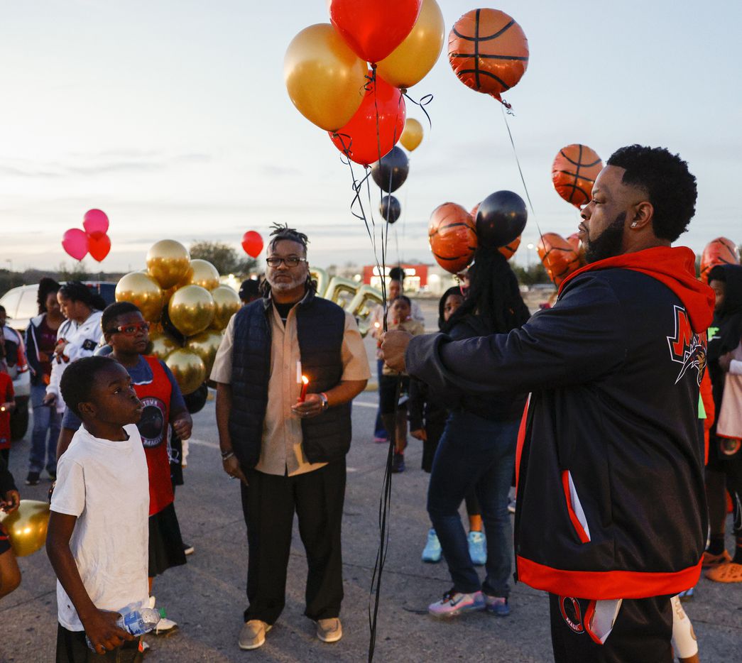 Coach Lo Williams hands out balloons before a balloon release in memory of 11-year-old...