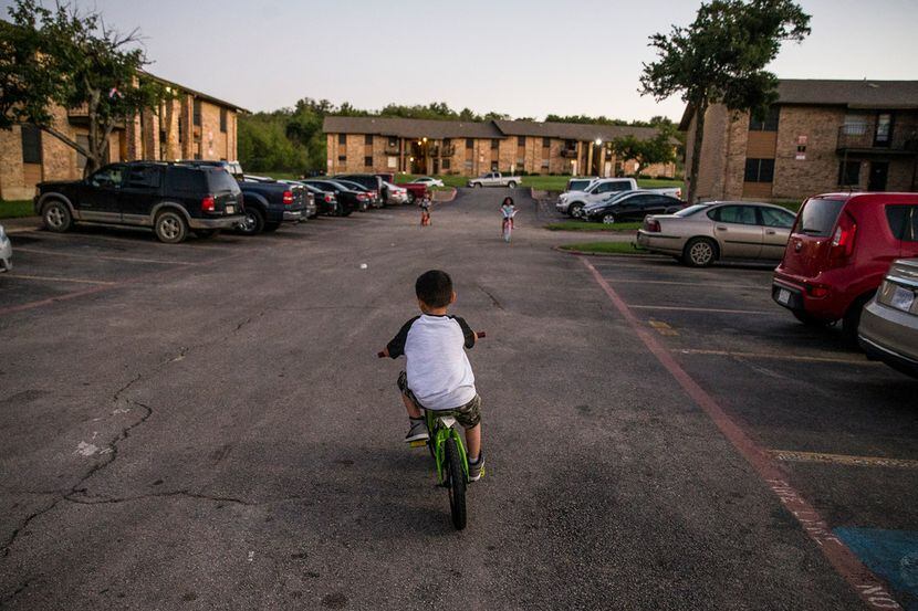 Isaac Guevara, 7, plays on his bike in front of his home at the Mountain View Apartments in...