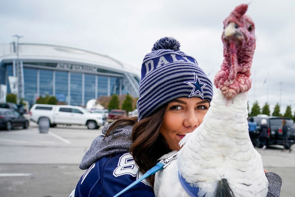 Callie Taylor poses with Tom, the Tailgate Turkey, as fans tailgate before an NFL football...