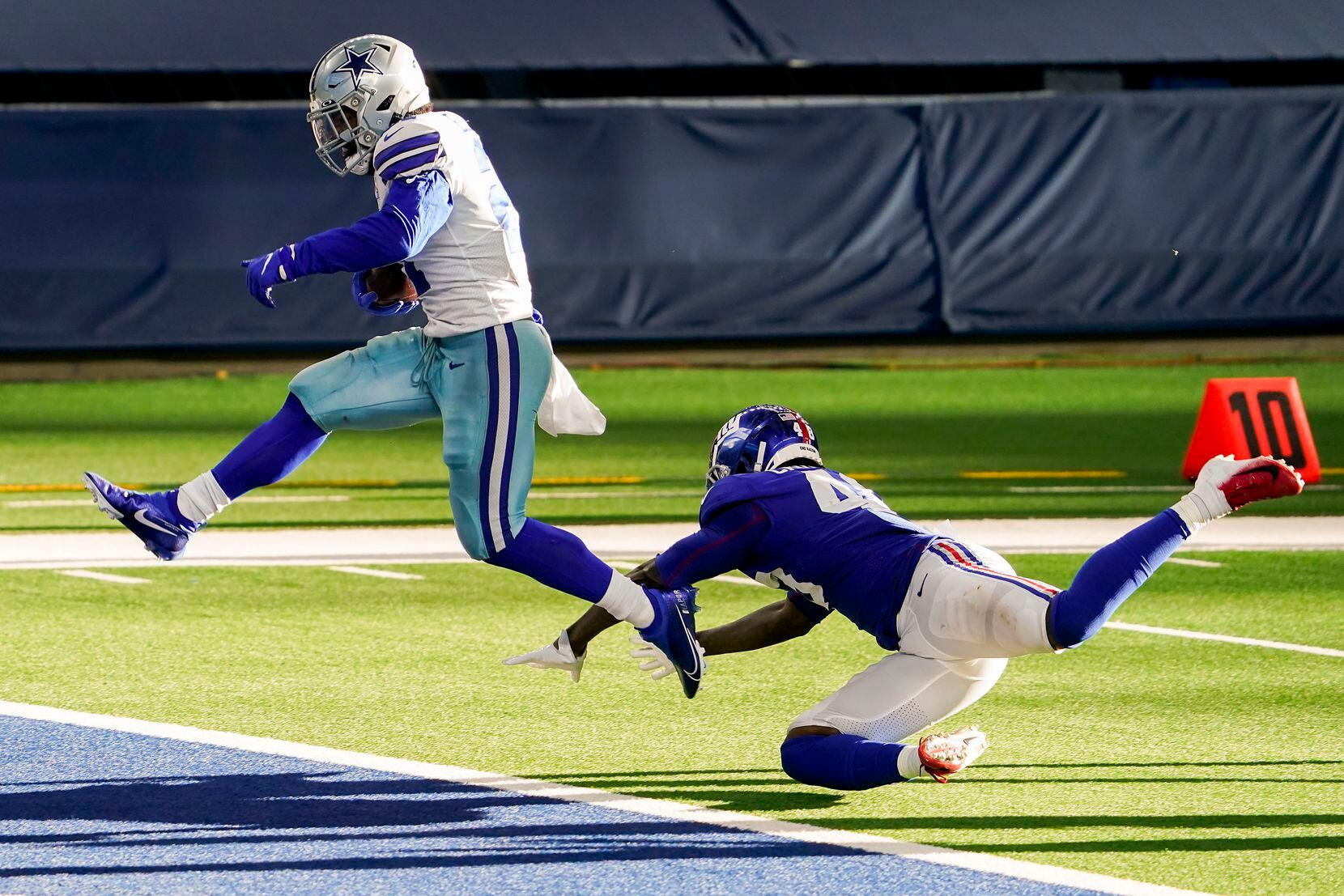 Dallas Cowboys running back Ezekiel Elliott scores past New York Giants linebacker Tae Crowder on a 12-yard touchdown run during the third quarter of an NFL football game at AT&T Stadium on Sunday, Oct. 11, 2020, in Arlington. (Smiley N. Pool/The Dallas Morning News)