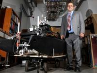 Dr. David Lary, Professor of Physics, stands next to an autonomous boat Tuesday, July 5,...