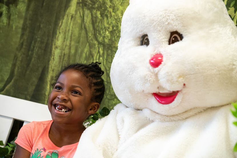 Alissia Dillard, 6, poses for pictures with the Easter Bunny during an Easter celebration at...