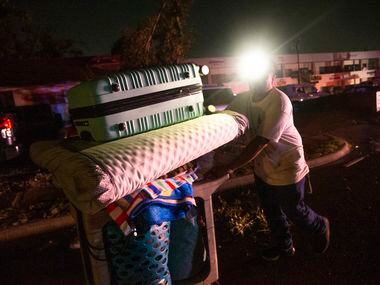 Antonio Gonzalez moves items from his home on Glenrio Lane, which sustained significant...