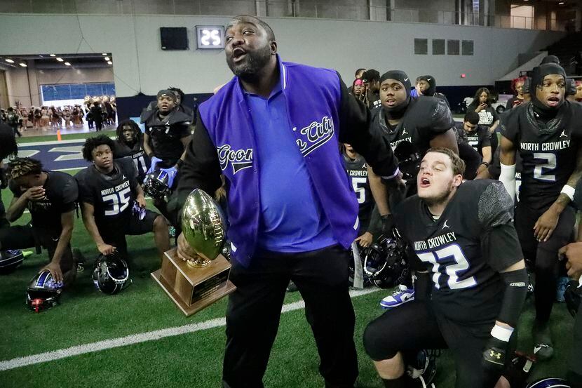 North Crowley High School head coach Ray Gates holds the trophy next to North Crowley High...