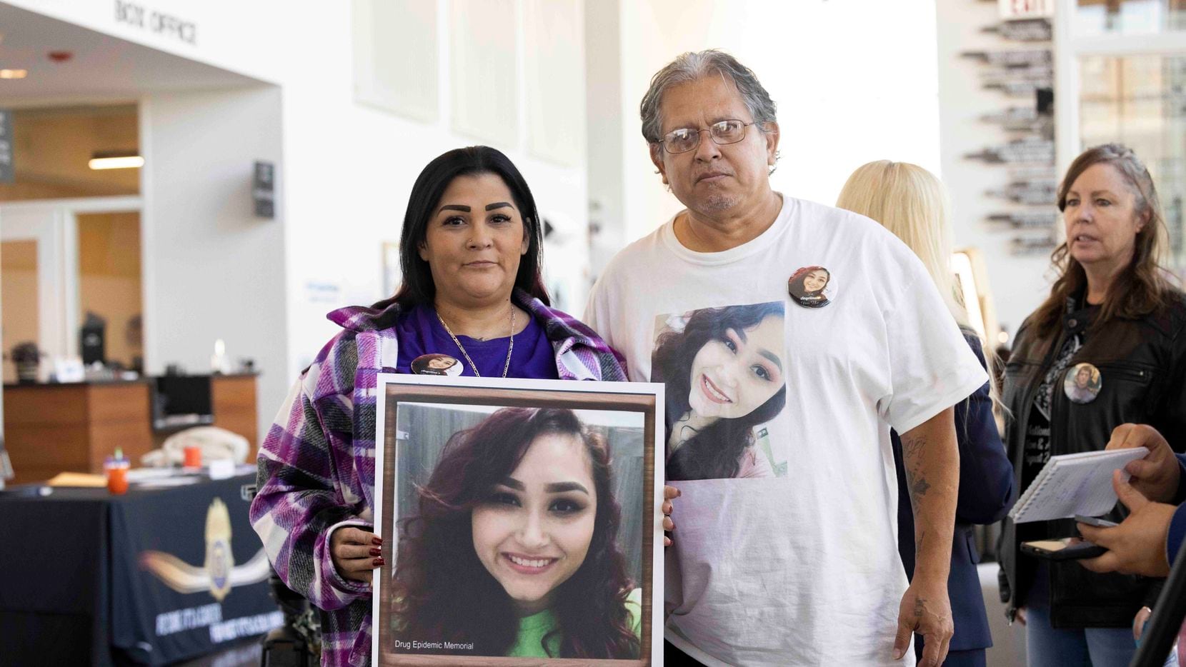 Christina Pena holds a photo of her late daughter Angelina Rogers while posing with husband...