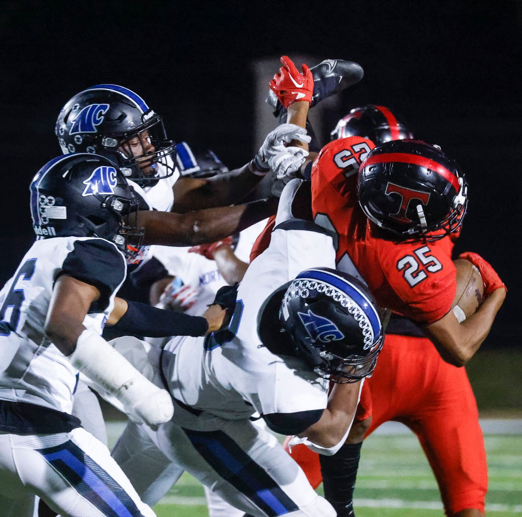 Trinity High School’s Antwan McGhee (25), right, is fouled by North Crowley defenders during...