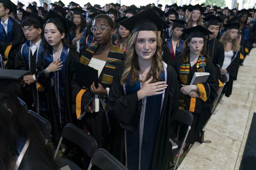 File - Students recite the national anthem during a commencement ceremony for the Georgetown...
