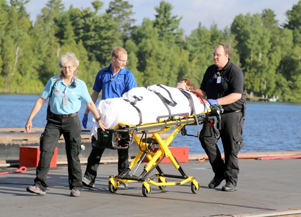 A camper is attended to by ambulance staff after arriving Thursday in Ely, Minn., by...