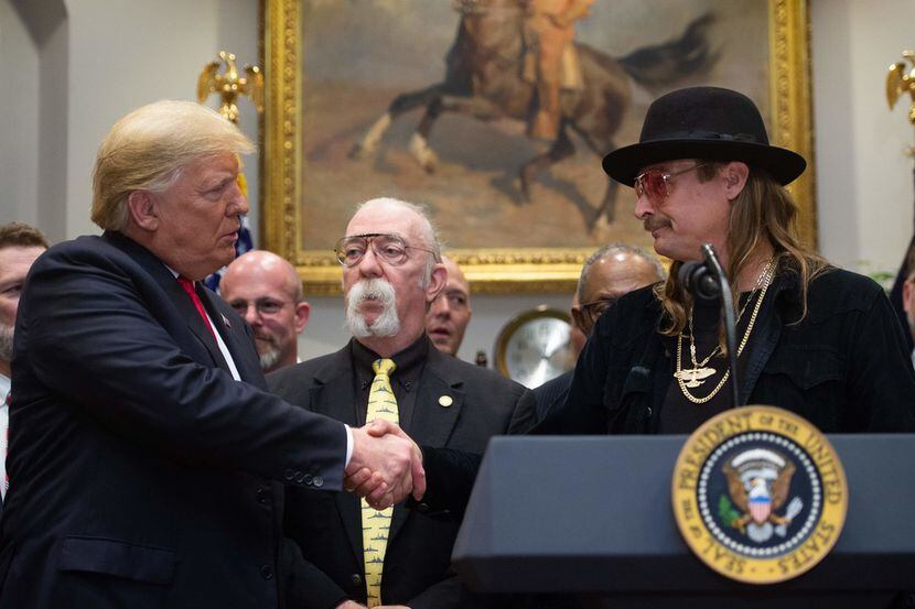 US President Donald Trump shakes hands with musician Kid Rock (R) after signing the...